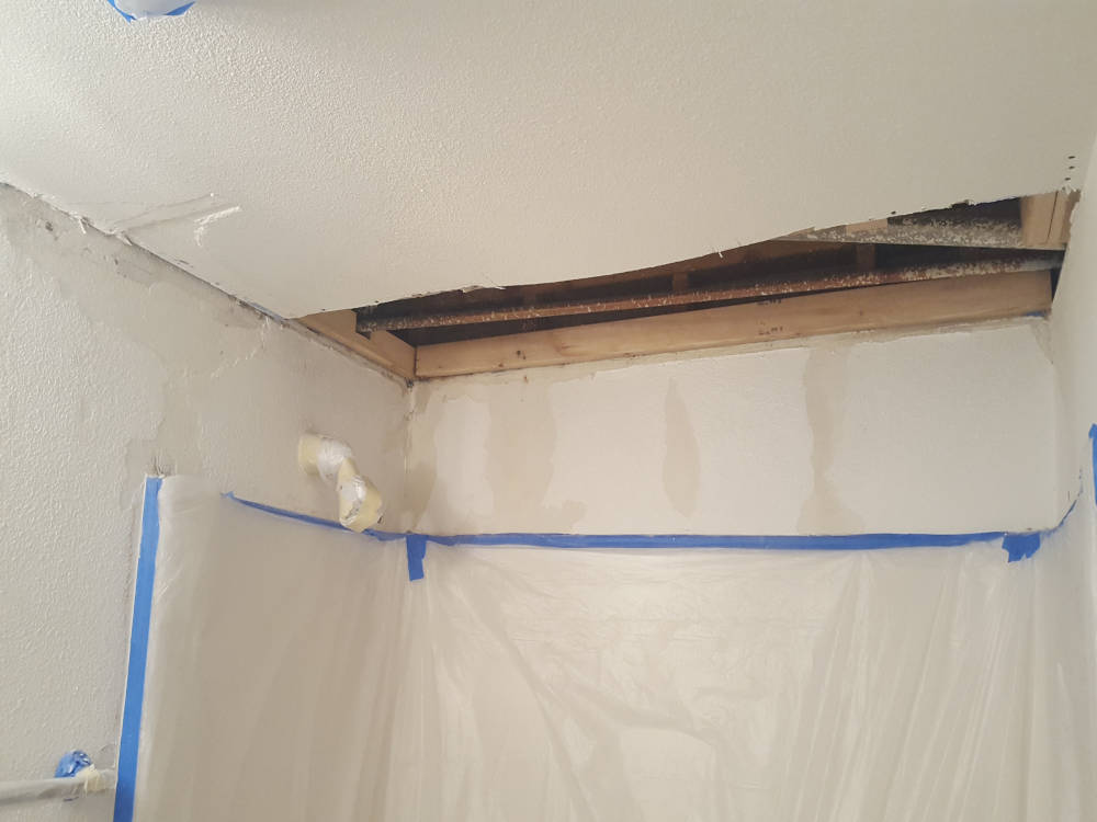 showing a ceiling in a bathroom that needs drywall repair.